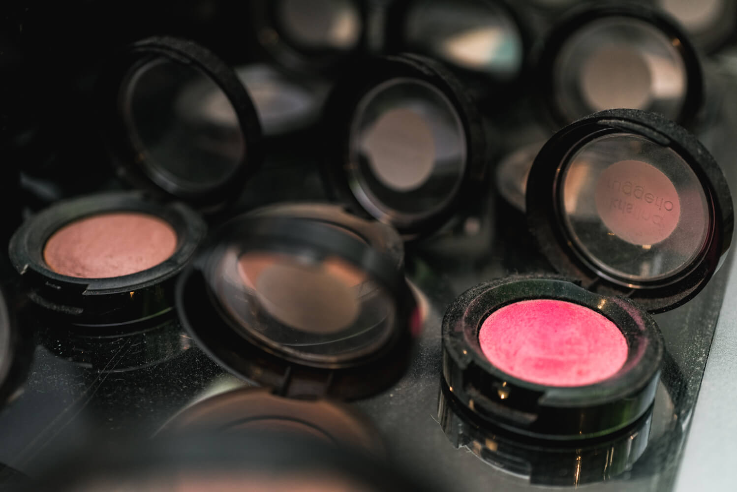 Close up shot of a diamond wedding ring shining on colorful eye shadows